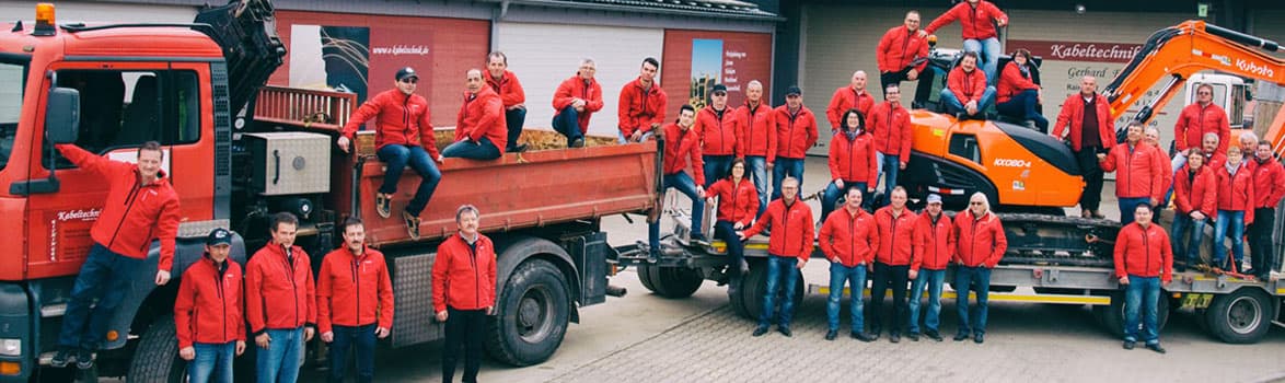 Das Team der Eichinger Kabeltechnik vor Fahrzeugen und Baumaschinen